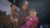 Wafaa Nasrallah poses for a portrait with her 4-year-old son, Ameer, and her 2-year-old daughter, Ayloul, at her tent at a camp for displaced Palestinians in Deir al-Balah, Gaza Strip, Dec. 28, 2024.