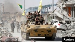 17일 시리아 락까를 완전 탈환한 시리아민주군(SDF) 대원들이 장갑차 위에서 승리를 자축하고 있다.