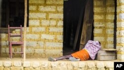 FILE - Man suffering from the Ebola virus lies on the floor outside a house in Port Loko Community, on the outskirts of Freetown, in Sierra Leone. 