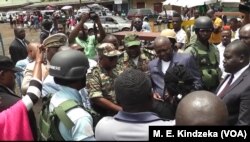 Governor Bernard Okalia Bilai guarded by military pleads with people not to leave, assuring them of their safety.