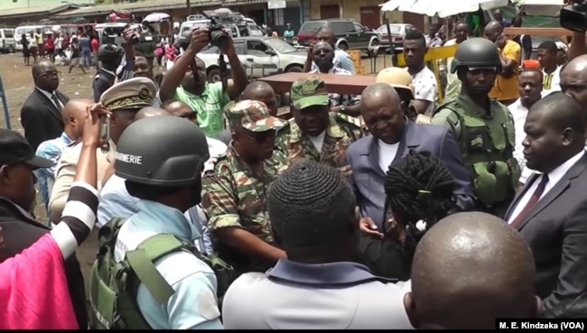 Governor Bernard Okalia Bilai guarded by military pleads with people not to leave, assuring them of their safety.