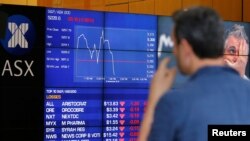 Seorang pria mengamati papan yang menampilkan harga-harga saham di Bursa Saham Australia (ASX) di Sydney, Australia (9/11). 