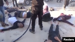 FILE - A still image taken from a video posted to a social media website on April 4, 2017, shows people lying on the ground, said to be in the town of Khan Sheikhoun, after what rescue workers described as a suspected gas attack in rebel-held Idlib, Syria.