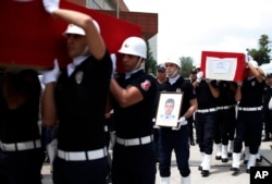 Turkish police officers carry the coffin of slain police officers Serdar Kazar and Isa Ipek, killed in an attack by Kurdish rebels overnight, in the the city of Adana, southern Turkey, July 31, 2015.