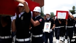 Turkish police officers carry the coffin of slain police officers Serdar Kazar and Isa Ipek, killed in an attack by Kurdish rebels overnight, in the the city of Adana, southern Turkey, July 31, 2015.