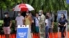 People wait in line at a walk-up testing site for COVID-19 during the new coronavirus pandemic, June 30, 2020, in Miami Beach, Fla. 