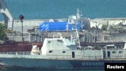 FILE - A still image taken from video footage shows blue tarpaulins covering equipment at the port of Feodosia, Crimea, July 11, 2017.