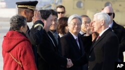 U.S. Vice President Mike Pence, right, and U.S. Gen. Vincent Brooks, commander of the United Nations Command, U.S. Forces Korea and Combined Forces Command, salute each other upon Pence's arrival at Osan Air Base in Pyeongtaek, South Korea, Feb. 8, 2018.