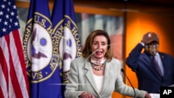 House Speaker Nancy Pelosi of Calif., with House Majority Whip James Clyburn of S.C., back right, speaks during a news conference on Capitol Hill, May 27, 2020, in Washington.