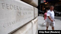 Orang-orang berjalan melewati gedung Federal Reserve di New York, 14 September 2008. (Foto: REUTERS/Chip East)