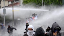 Demonstrators are sprayed by riot police water canons during a protest against Chile's government in Concepcion, Chile October 31, 2019. REUTERS/Jose Luis Saavedra