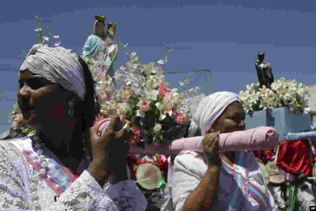 Women carry statues of Our Lady of the Rosary and St. Benedict during the annual Afro-Christian Congada celebration in Catalao, Goias state, Brazil, Oct. 9, 2015. Our Lady of the Rosary represents the African divinity Yemanja, or Sea Mother, and St. Bened