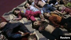 Xác trẻ em nằm trên mặt đất ở Houla, gần thành phố Homs, mà theo lời những người chống chế độ nói các em bị lực lượng an ninh chính phủ giết 