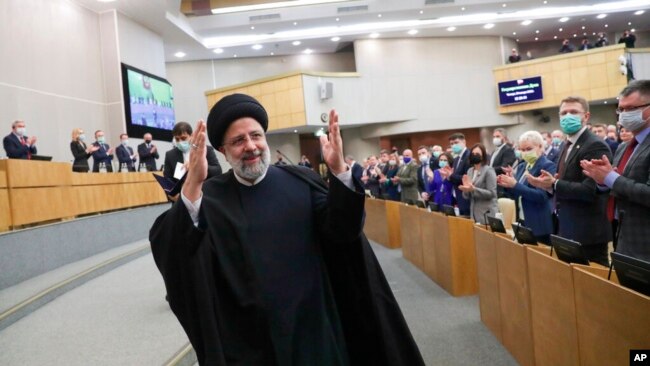 In this handout photo released by the Russian Federation Press Service, Iranian President Ebrahim Raisi gestures after delivering his speech at the State Duma, the lower house of the Russian parliament, in Moscow, Jan. 20, 2022.