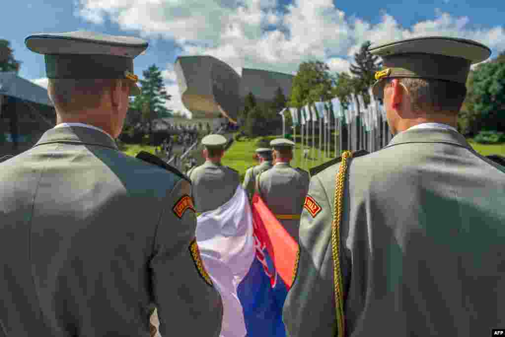Slovak honor guard soldiers wait to rise the flag to commemorate the 70th anniversary of Slovakia&#39;s National Uprising in Banska Bystrica. In a two-month period during World War II nearly 60,000 soldiers and 18,000 guerrillas were defending a compact region in Central Slovakia against German troops.