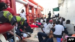 Migrants rest on the desk of the Ocean Viking rescue ship, operated by French NGOs SOS Mediterranee and Medecins sans Frontieres (MSF), during an operation in the Mediterranean Sea, Aug. 13, 2019.