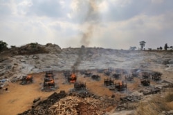 Funeral pyres of 25 COVID-19 victims burn at an open crematorium on the outskirts of Bengaluru, India, May 5, 2021.