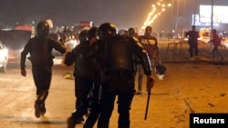 Policemen and soccer fans argue during a scuffle as fans attempt to enter a stadium to watch a match, on the outskirts of Cairo February 8, 2015.
