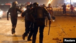 La police essaie d'empêcher les fans de rentrer dans le stade après des violences, au Caire, le 8 février 2015.