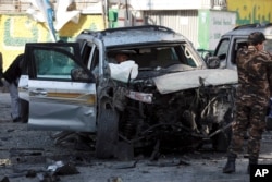 Security forces inspect a damaged vehicle at the site of a bomb explosion in Kabul, Afghanistan, Nov. 16, 2020.