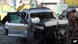 Security forces inspect a damaged vehicle at the site of a bomb explosion in Kabul, Afghanistan, Nov 16, 2020.