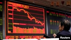 FILE - An investor watches a board showing stock information at a brokerage office in Beijing, China, Oct. 8, 2018.