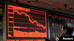 FILE - An investor watches a board showing stock information at a brokerage office in Beijing, China, Oct. 8, 2018.