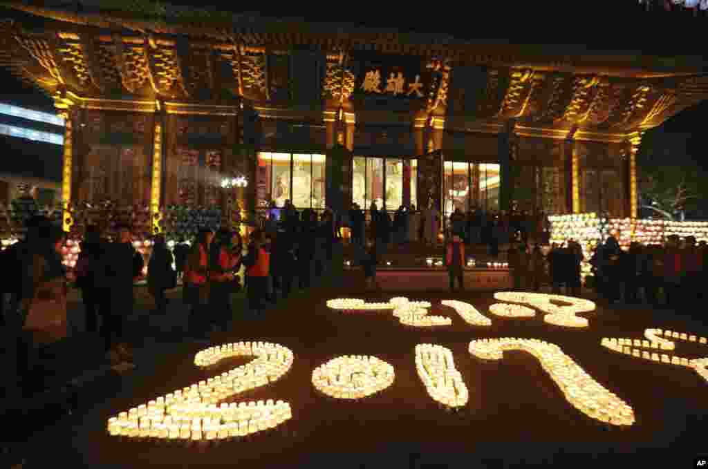 Buddhists light candles during New Year celebrations at Jogye Buddhist temple in Seoul, South Korea, Jan. 1, 2017.