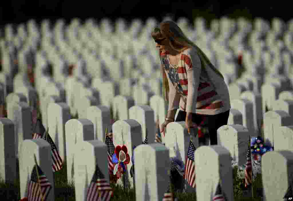 Patrica Kelly pauses at her father&#39;s grave at Levenworth National Cemetery on the eve of Memorial Day, May 27, 2018, in Leavenworth, Kansas.