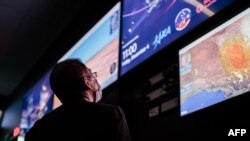 Toshio Yasuma, adviser to the director of Japan's space agency JAXA, looks at monitors in the Range Operations center of the Royal Australian Air Force's (RAAF) Woomera Range Complex in Woomera in South Australia on Dec. 4, 2020.