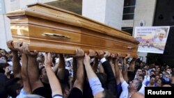 FILE - The body of Vittorio Casamonica is carried into a Roman Catholic basilica in a Rome suburb as a banner with his picture reads "You have conquered Rome, now conquer paradise" hangs to the entrance where the funeral was celebrated, Aug. 20, 2015.