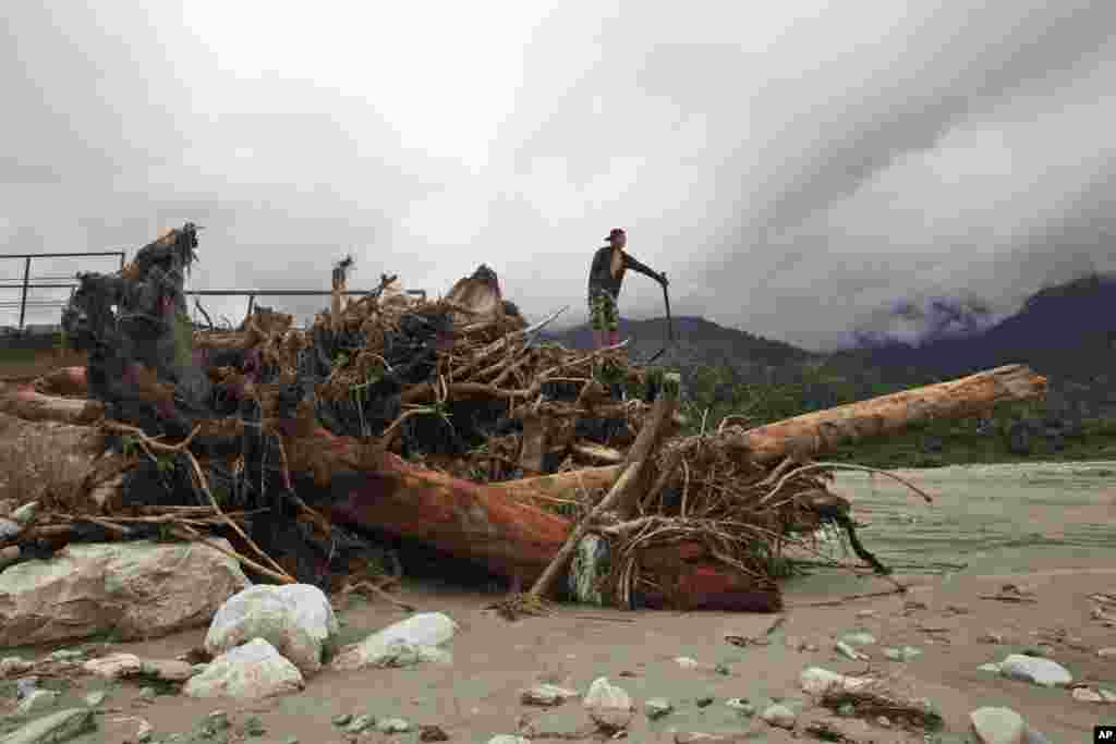 A Nepalese man stands on a foot bridge destroyed by flood waters in Thulakhet, near Pokhara in Nepal. Landslides caused by heavy rains buried several mountain villages in Nepal on Thursday.