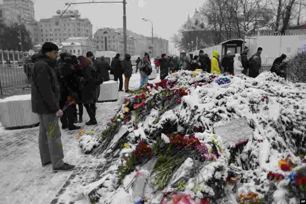 People lay flowers in front of the French Embassy in Moscow, Russia, Nov. 15, 2015, in honor of the victims of the Paris attacks Friday.