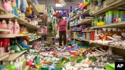 Nina Quidit cleans up the Dollar Plus and Party Supplies Store in American Canyon, California, after a major earthquake, Aug. 24, 2014. 