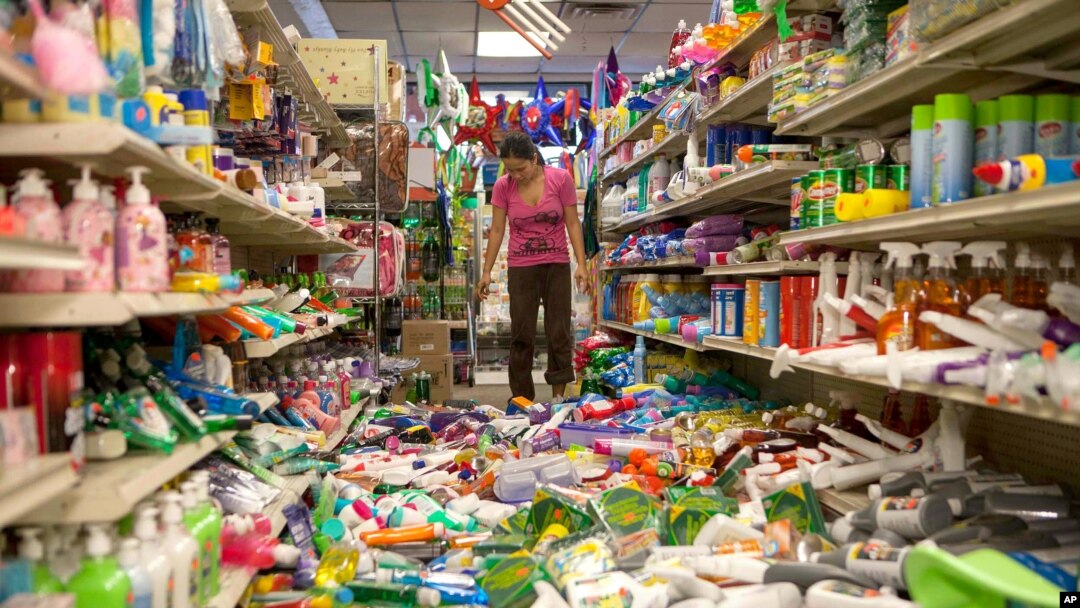 Nina Quidit cleans up the Dollar Plus and Party Supplies Store in American Canyon, California, after a major earthquake, Aug. 24, 2014. 