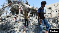 Palestinos inspeccionan una casa destruida en un ataque israelí, en medio del conflicto entre Israel y Hamas, en el campo de refugiados de Nusairat, en el centro de la Franja de Gaza, el 9 de julio de 2024.