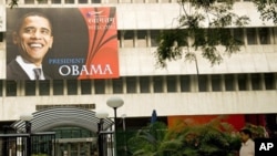 An Indian pedestrian walks past a billboard welcoming US President Barack Obama outside The American Centre in New Delhi, 04 Nov. 2010.