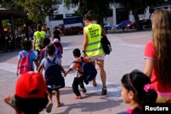 Volunteers escort refugee children at the volunteer-run "Refugee Education Chios" school on the island of Chios, Greece, Sept. 7, 2016.