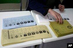 An official prepares ballot voting papers with names of political parties at a polling station during the municipal elections, in Ankara, Turkey, March 31, 2019.