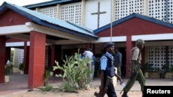 Des policiers devanmt une église catholique avant la célébration du dimanche de Pâcquesvice in Garissa, Kenya, April 5, 2015.