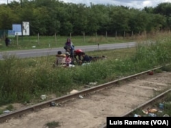 Refugees rest on the side of the road in northern Serbia.