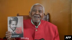 FILE - Gitu Wa Kahengeri, Secretary General of the Mau Mau War Veterans Association, holds one of the books he has written as he speaks to AFP during an interview at his home in Kilimambogo, Kiambu County, on October 13, 2023.