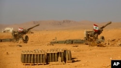 Lebanese national flags are seen set on top of cannons inside a base during a media trip organized by the Lebanese army, on the outskirts of Ras Baalbek, northeast Lebanon, Aug. 28, 2017. Lebanon's Hezbollah TV is reporting that IS militants started leaving the border area with Syria on Monday as part of a negotiated deal to end the extremist group's presence there.