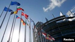 FILE - Flags of European Union member states fly in front of the European Parliament building in Strasbourg, France, April 15, 2014. 