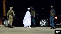 L'ancien président Yaya Jammeh (C), le dirigeant de la Gambie depuis 22 ans, se dirige vers l'avion pour aller en exil, à l'aéroport de Banjul, le 21 janvier 2017.