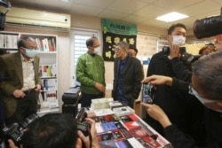 Lam Wing-kee, center right, is congratulated by Taiwan's Legislative Yuan Speaker Yu Shyi-kun, center left, on the opening day of his new book shop in Taipei, April 25, 2020.