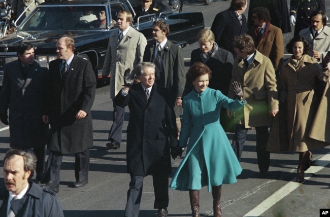 FILE - This Jan. 20, 1977 file photo shows President Jimmy Carter and First Lady Rosalynn Carter waving as they walk down Pennsylvania Avenue in Washington after Carter was sworn in as the nation's 39th president. (AP Photo)