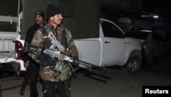 A Pakistani customer looks in a mirror before buying a pair of sunglasses from a roadside vendor in Islamabad.