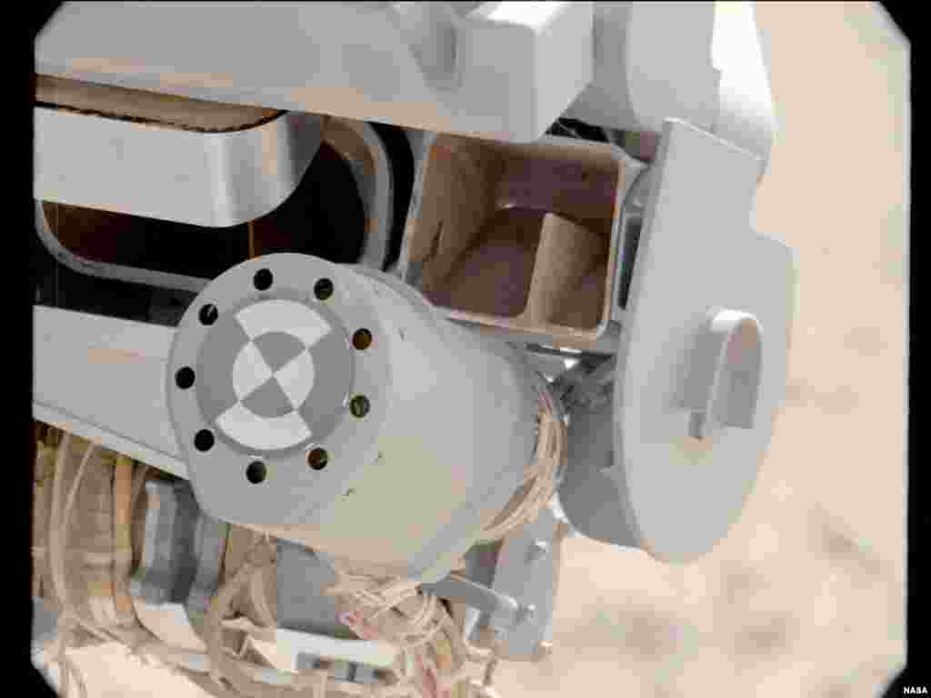 큐리오시티가 10일 전송한 사진. 화성의 가는 모레를 제거하는 실험 장면이 담겨있다.
