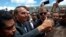 FILE - Brazil's President Jair Bolsonaro flashes a thumbs up as he greets supporters after attending a Changing of the Guard at the Planalto Presidential Palace, in Brasilia, Brazil, Thursday, Nov. 28, 2019